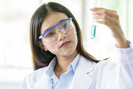 研究和学习的亚裔年轻女学生科学家生物学烧瓶化学家女士实验女性化学手套工人管子图片