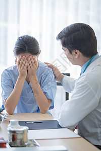 医生照顾一位有病的 伤痛和忧伤的妇女医师医院男人诊断蓝色女士治疗考试从业者药品图片