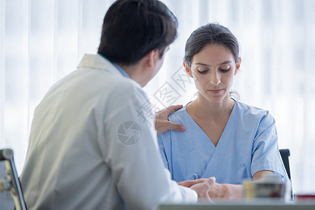 医生照顾一位有病的 伤痛和忧伤的妇女帮助治疗桌子病人疼痛专家卫生疾病蓝色医师图片