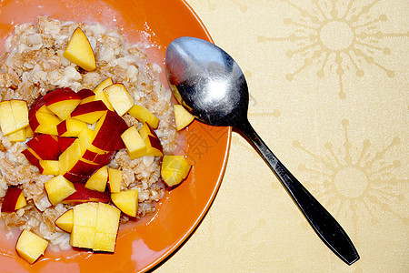 燕麦粥加切开的新鲜桃子 盘子里有汤匙和素食早餐桌子麦片稀饭饮食食物小吃薄片谷物减肥健康饮食图片