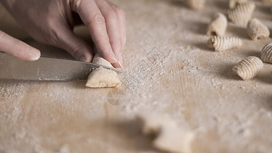 用全麦面粉制作自制素食意大利面的特写过程 家庭厨师在木砧板上切面团 传统意大利面 女人在厨房里做饭手工午餐木板女性饺子炊具产品食图片