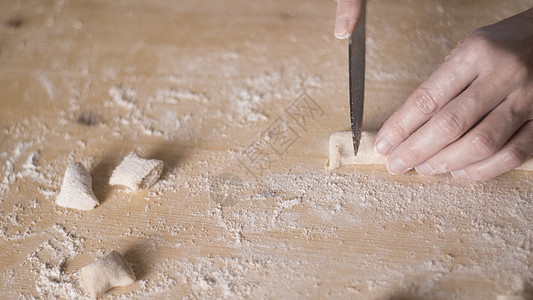 用全麦面粉制作自制素食意大利面的特写过程 家庭厨师在木砧板上切面团 传统意大利面 女人在厨房里做饭食谱女士女性烹饪美食木板手工糖图片