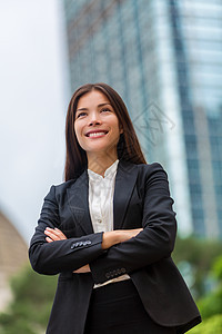 对香港充满信心的亚洲女商务人士 女商务人士站在户外 身穿西装 背景为城市背景 香港年轻的多种族华人亚裔/白人专业人士图片