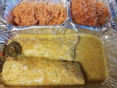 含绿色酱汁和金属盘中大米的enchiladas午餐胡椒托盘辣椒图片