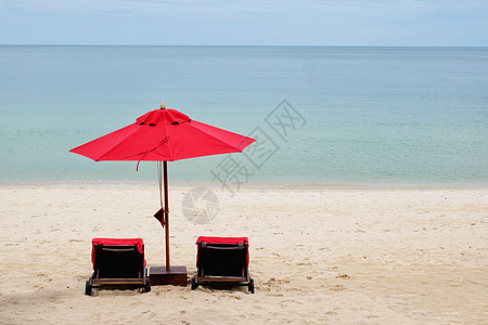红伞在沙滩上太阳旅游晴天地平线热带日落躺椅旅行椅子海洋图片