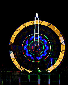 夜间旋转的嘉年华巨型摩天轮 夜间旋转巨轮的慢速快门照片绘画纺纱乐趣旅行几何学车轮墙纸技术喜悦蓝色图片