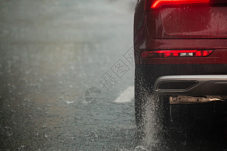 红车轮在日光城市快速行驶 有选择地集中关注 从中流出雨水运动车辆流动喷涂速度沥青风暴天气季风运输图片