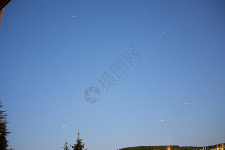 蓝夜天空有星星宇宙科学地球地平线树木绿色天篷天体蓝色云带背景图片