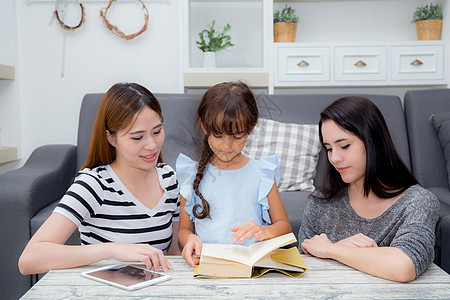 家庭幸福母亲 姑母 姨妈 freind和女儿教书微笑童年沙发孩子们教育活动阅读妈妈房间教学图片