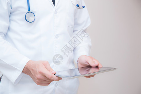 医生在白色背景的数码平板电脑上工作男性诊断医院互联网药片屏幕治疗笔记本卫生展示图片