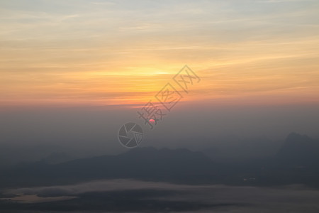 美丽的日落或日出天空 在云层之上 光辉照耀太阳戏剧性阳光橙子地平线旅行季节天堂天气晴天图片