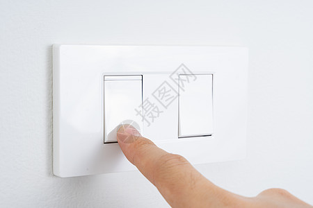 在家里用白墙特写手指打开或特写白灯开关 省电节能 复制文本的空间盘子房子技术按钮住宅力量家庭公用事业环境塑料图片
