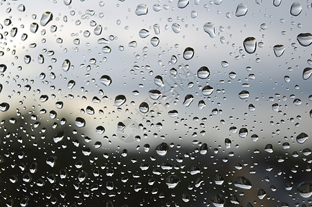 窗户上下着雨滴气泡玻璃水滴下雨宏观天空天气液体图片