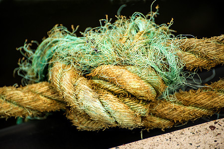 厚厚的编织船绳鞭打港口绿色码头船运黄色背景图片
