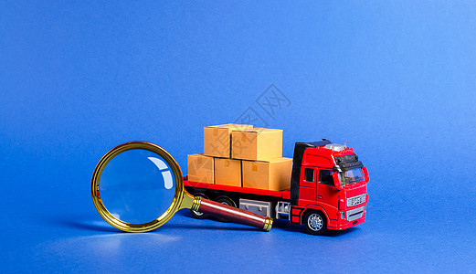 满载箱子和放大镜的红色卡车 搜索承运人和运输路线 跟踪货运 货物和产品的过境 海关检查和费用支付 商业图片