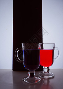 黑色和白色背景上两杯眼镜的双影带 蓝色和红色液体电影坡度设计玻璃曲线反射美食瓶子酒精酒杯图片