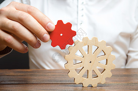 商务人士将一个小的红色齿轮连接到一个大齿轮 建立业务流程和沟通的象征意义 提高效率和生产力 成功的最佳商业公式图片