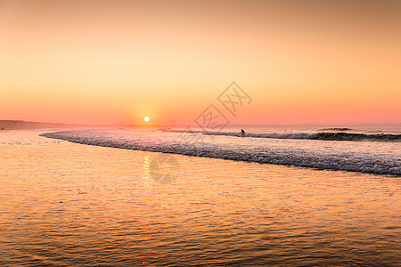 橙色日落晴天天空反射海滩日出场景海洋波浪地平线海岸图片