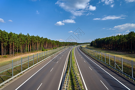 穿越森林的一条双车道沥青高速公路图片