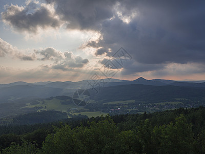 Lusatian 山脉 全景 从捷克与德国边境的 Hochwald (Hvozd) 山欣赏阳光蓝绿色山林和粉红色多云日落天空背景图片