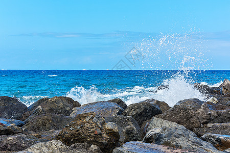 沿海岩石上断水的冲浪图片