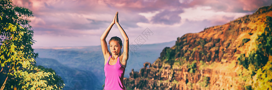 在Kauai自然的全景横幅上举行瑜伽务虚会 亚洲女孩在日落时进行室外冥想 坐在树顶上祈祷用手坐下来摆姿势图片