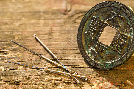 带有古中国硬币的针刺针现金工具中医治愈者疗法自然健康加热古董保健背景图片
