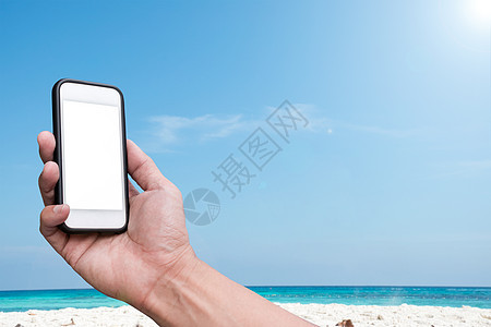 沙滩和蓝天空背景上手持智能手机商务旅行游客购物支付细胞海滩网络互联网服务图片