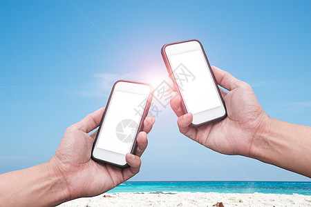 沙滩和蓝天空背景上手持智能手机技术海滩商业网络细胞电话支付职场互联网人士图片