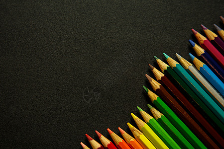 彩色铅笔在黑暗背景上形成钉钉用具木头紫色染色粉色红色绘画紫丁香绿色艺术图片