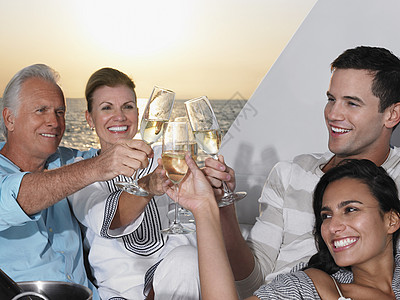 年轻夫妇和中年夫妇在游艇加香槟的祝酒节上放松图片