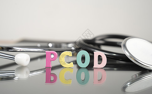 PCOD或多细胞卵巢综合症医疗或保健疾病概念 显示作为背景的字母和听诊器图片
