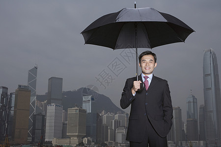 穿着雨伞微笑的商务人士肖像图片