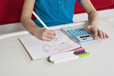 写书做功课的女孩的中心女性沙发童年学校教育孩子写作计算器工作年龄图片