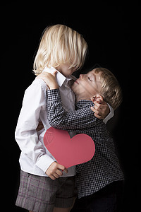 亲吻宝宝一个男孩亲吻他的金发妹妹的甜蜜照片背景