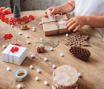 孩子把圣诞礼物包装在手纸上 白毛卷白色雪花寒假红色儿童工艺礼物精神手工假期新年图片