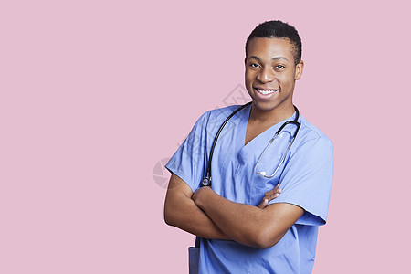 混合种族男性外科医生用手臂跨过粉红背景的血压护士双臂微笑男人医院职业摄影幸福成人短发图片