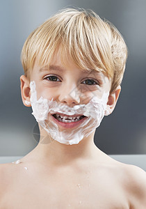 白种男孩脸上有剃须霜的肖像图片