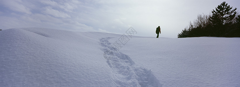 在雪地上行走的人 留下足迹的痕迹在一片土地上天气状况自然天气孤独脚印天空全景地平线白色踪迹图片