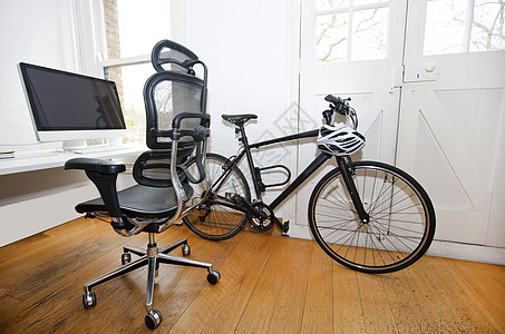 办公室内部的PC 服务台和自行车计算机家具砖墙显示器窗户座椅房间椅子桌子生活图片