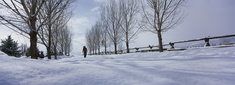 一捧土在雪覆盖的土地上行走的人白色栅栏天气天气状况天空全景自然背景