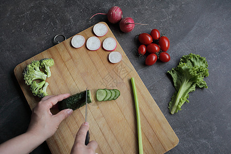 在灰色桌子上的剪切板上 砍了一只黄瓜砧板饮食横幅营养健康草药午餐厨房菜单西红柿图片