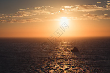 笼罩着岩石的阴云海洋上 大面积的日落天空海浪海滩旅游紫色地平线日出旅行摄影假期图片