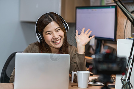 亚洲商业妇女使用技术笔记本电脑和从胡图人工作自由职业者办公室相机微笑视频居住学习商务手机职场图片