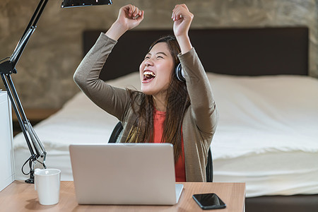 亚洲商业妇女使用技术笔记本电脑和从胡图人工作女性网络学习营销人士卧室职场舞蹈工人微笑图片