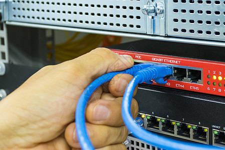 手握着连接兰港的网络电缆的人之手红色电脑服务互联网商业速度控制服务器金属宽带图片