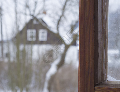 在模糊的冬季农村地貌雪中从木窗上查看 c图片