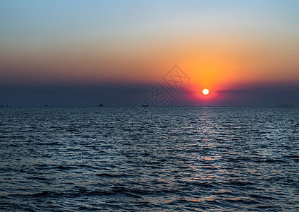 宁静的海面上美丽的日落 蓝色和橙色的光芒国家太阳橙子优美海岸地平线自由墙纸旅行戏剧性图片