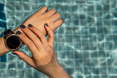 游泳池用手和智能手表的女性水池屏幕电话活动蓝色检查游泳展示时间互联网图片