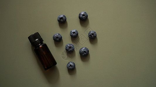 一瓶蓝莓种子基本油类和新鲜蓝莓疗法骨头滴管化妆品奶油芳香桌子浆果紫色香气图片